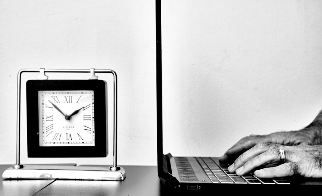 time and man typing on laptop